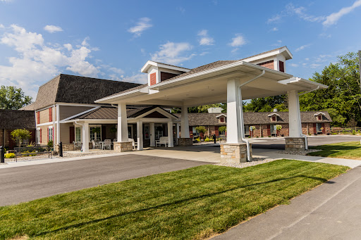 A welcoming hotel entrance with a well-maintained lawn and clear blue skies.