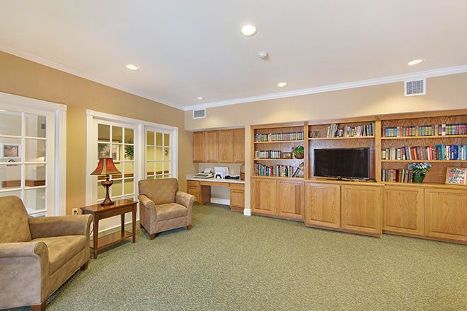 A cozy living room with a bookshelf, television, and comfortable seating.