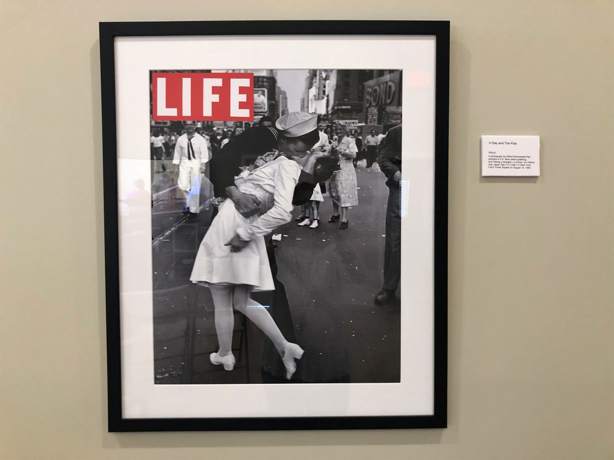 Historic V-J Day photograph featuring a sailor kissing a nurse in Times Square, captured on the cover of Life Magazine.