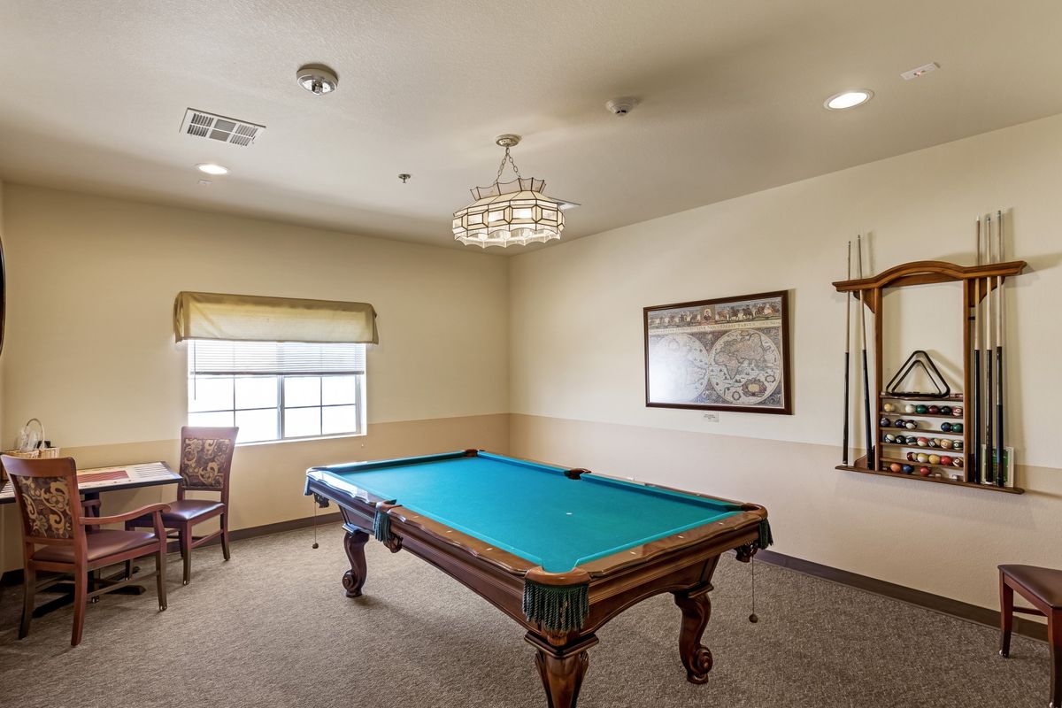 A cozy billiard room featuring a pool table and elegant lighting.
