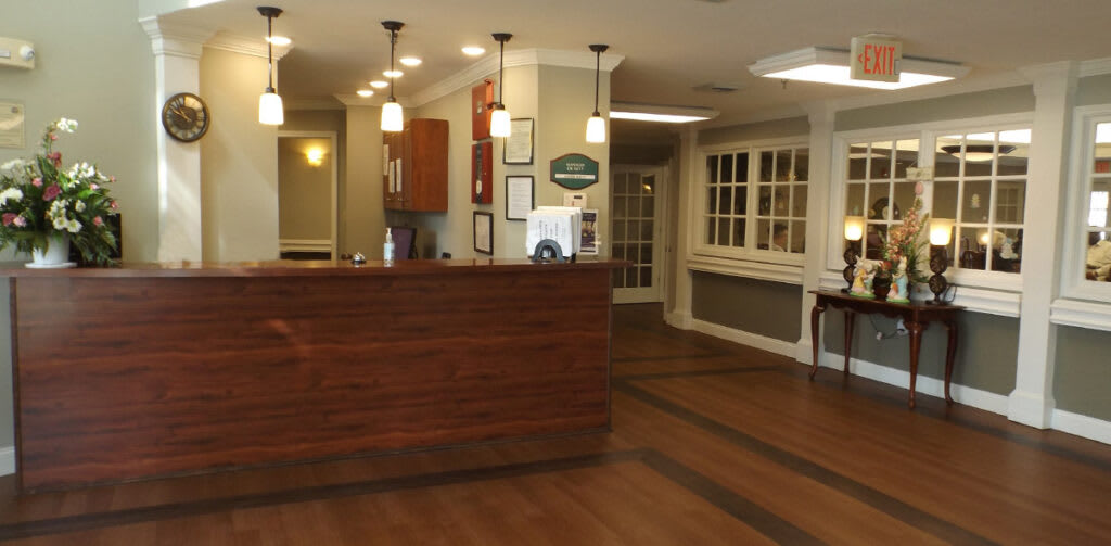 A neatly designed reception area featuring a wooden counter and modern lighting.