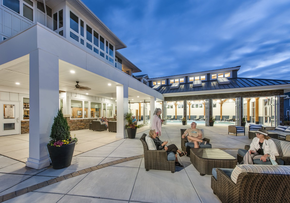 A modern residential patio with outdoor seating and people enjoying an evening gathering.
