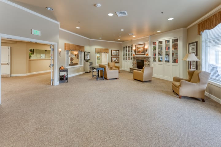 A spacious and well-lit lobby area with comfortable seating and carpeted flooring.
