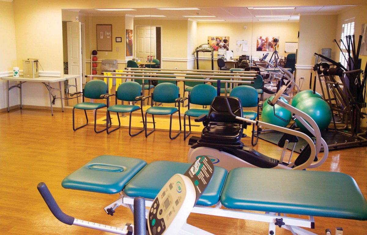 A gym with exercise equipment and seating area for workouts.