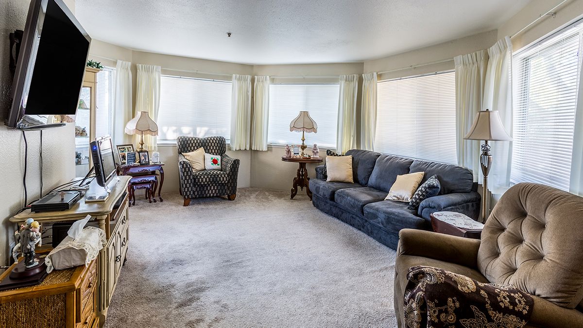 A cozy living room with comfortable furniture and ample natural light.