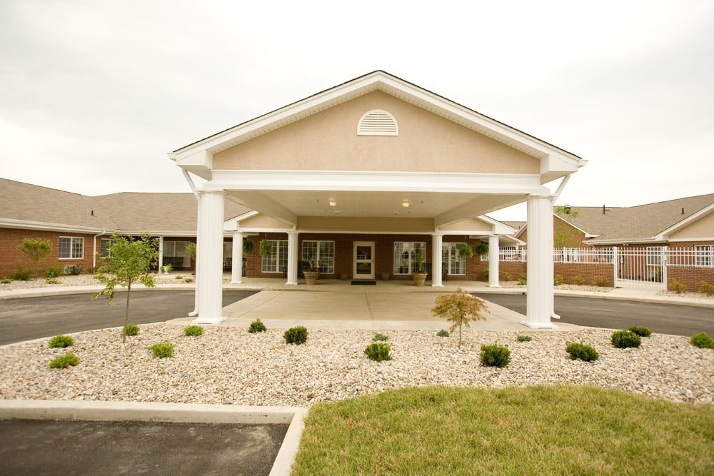 Front view of a building entrance with columns and landscaping.