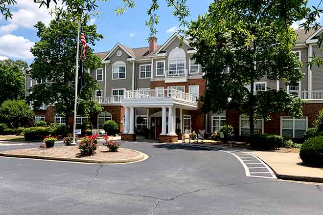 A residential building with a landscaped entrance on a sunny day.