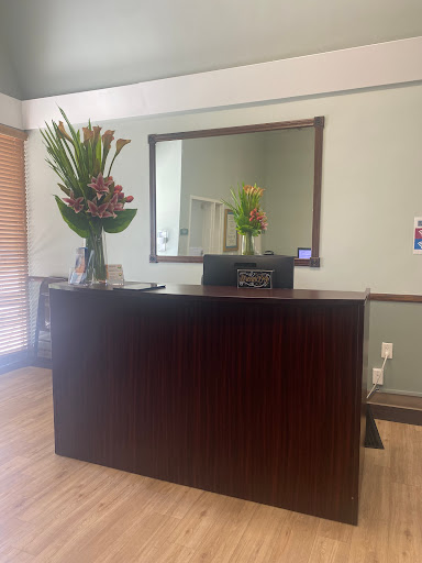 A welcoming reception area featuring a floral arrangement and a large mirror.