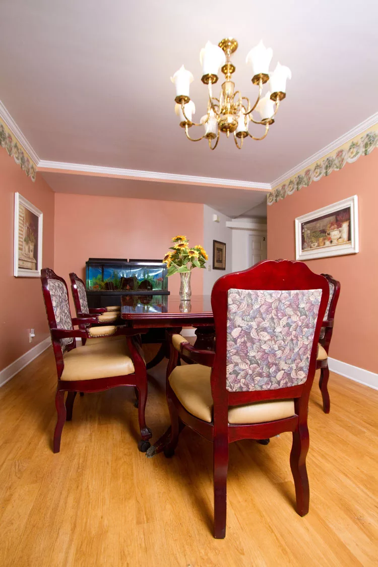 A well-decorated dining room with a wooden table, upholstered chairs, and a chandelier.