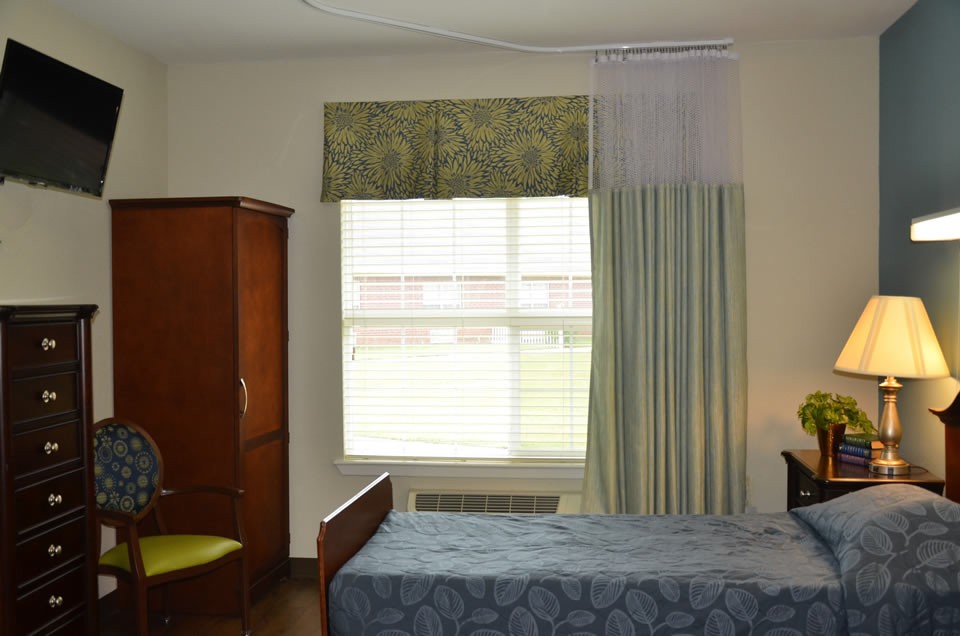 A minimalist bedroom with a bed, wardrobe, and a window with curtains.