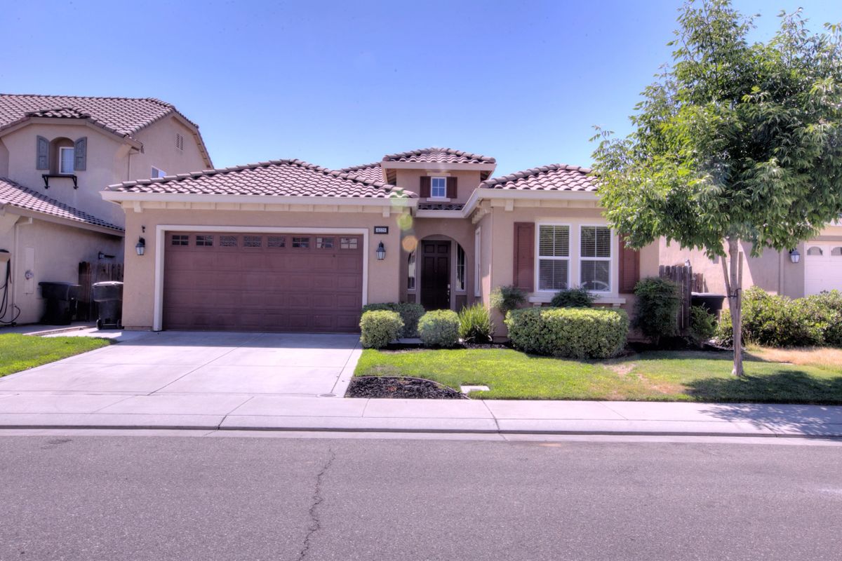A suburban single-story house with a garage and landscaped front yard.