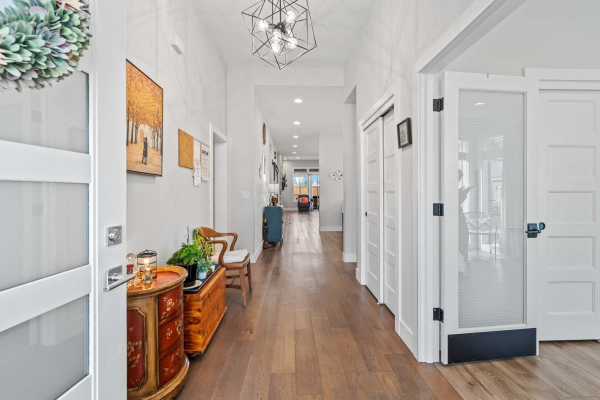 A modern, well-lit hallway with wood flooring and tasteful decor.