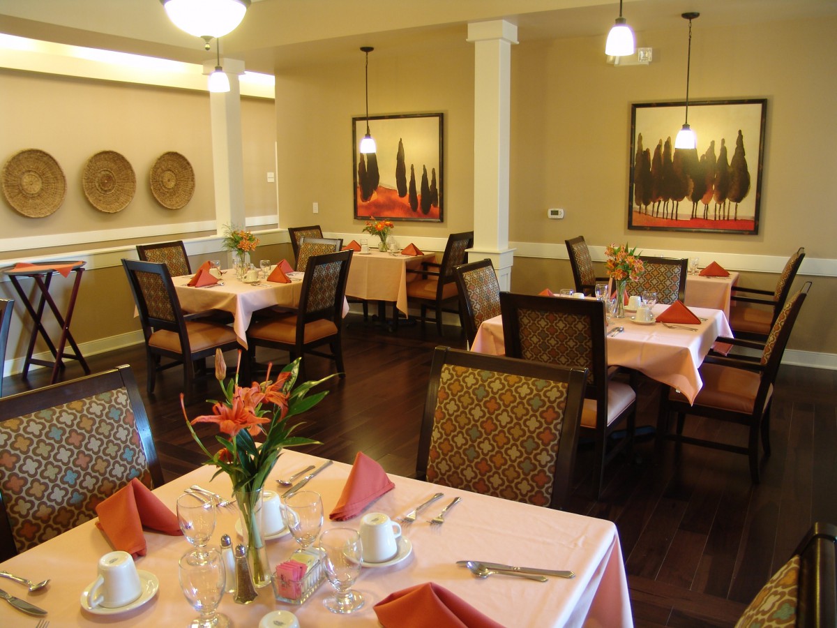A cozy and elegantly arranged dining area with neatly set tables and warm decor.