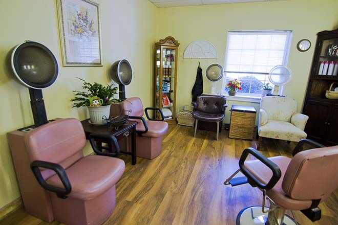 A cozy hair salon waiting area with chairs and salon equipment.