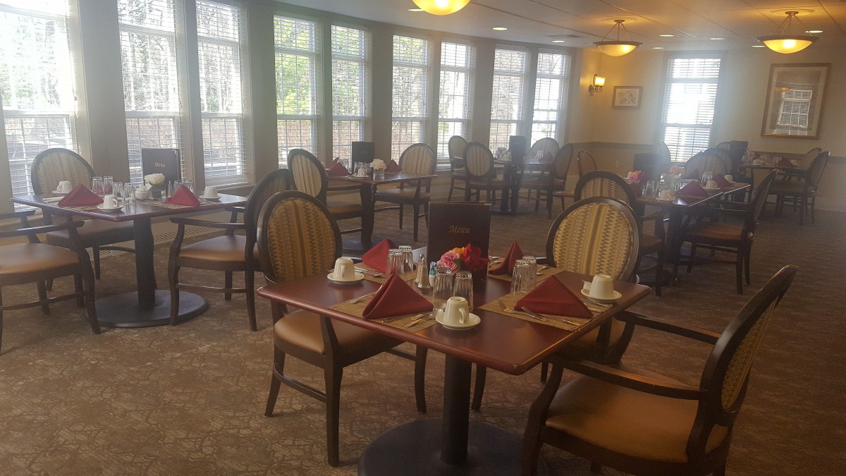An empty dining room with neatly set tables and chairs.