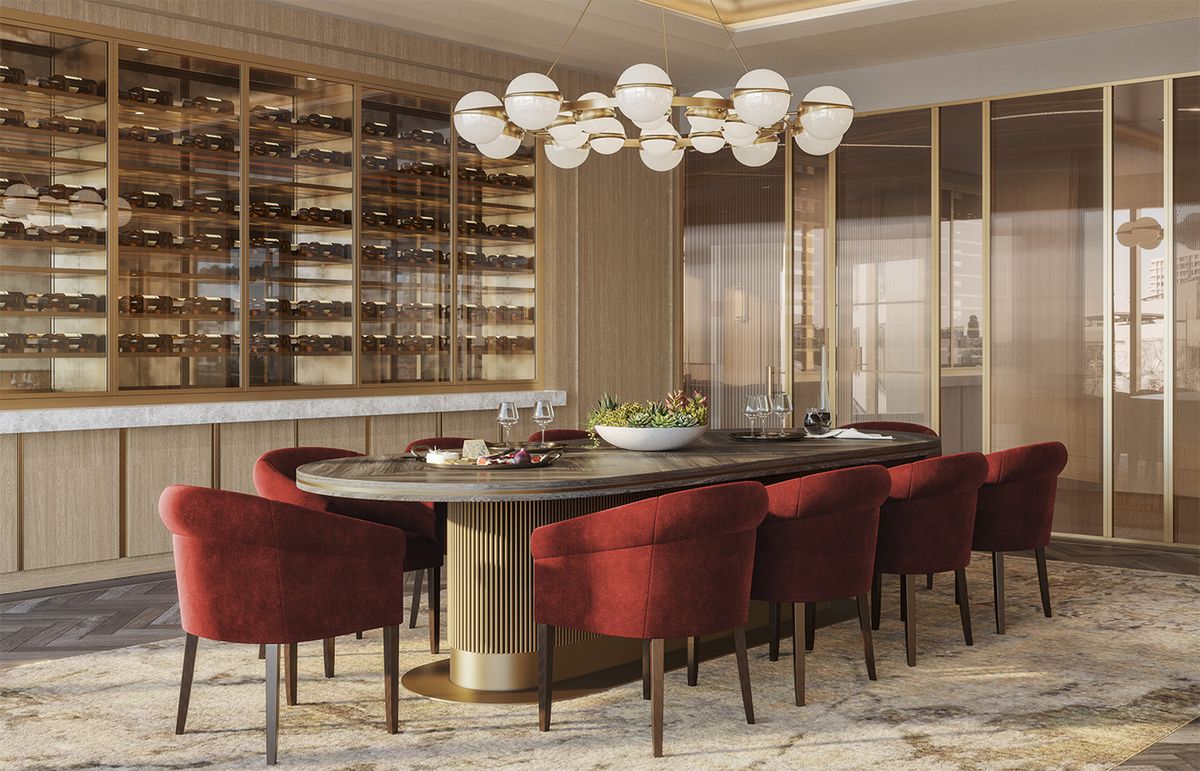 A modern dining room with an oval table and red chairs, featuring a wine rack and contemporary chandelier.
