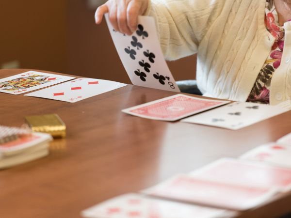 A person playing a card game at a table indoors.