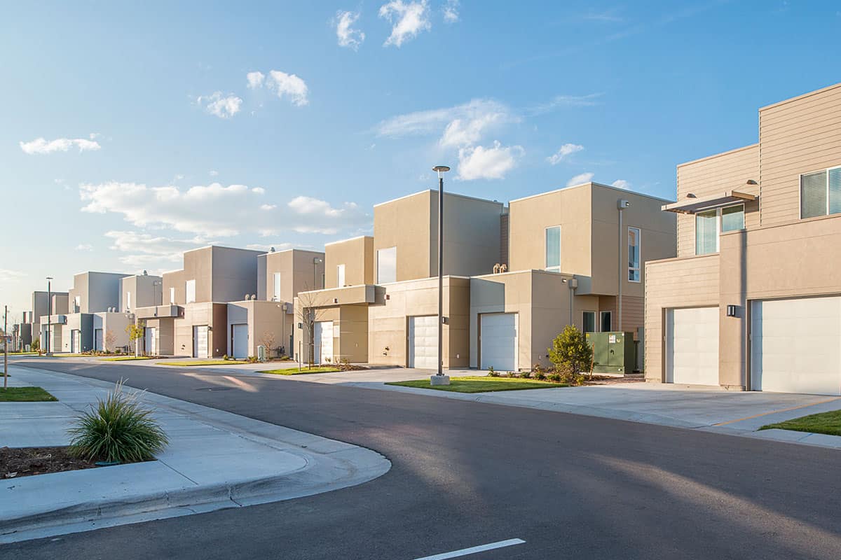 A modern suburban neighborhood with a row of contemporary houses on a sunny day.