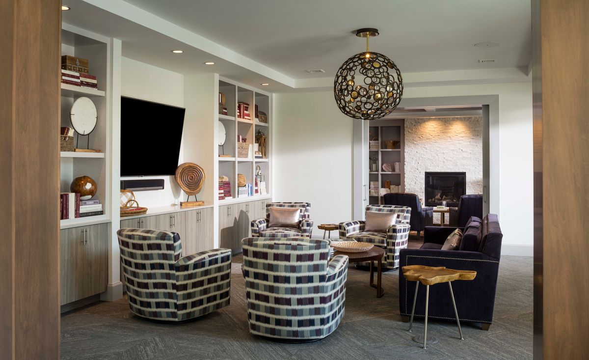 A modern living room with stylish furnishings and a prominent chandelier.