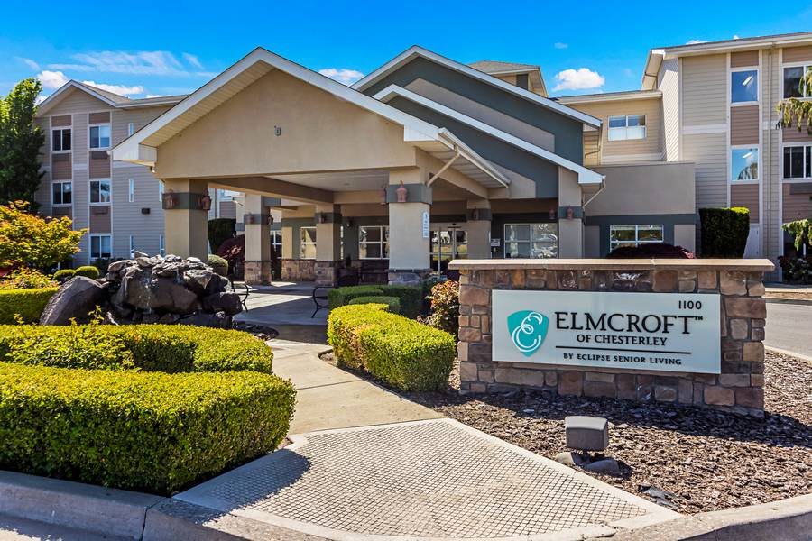 Entrance of a retirement community with landscaped surroundings and clear signage.