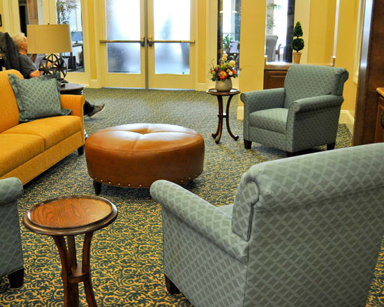 Cozy seating area with comfortable chairs and a couch in a warmly lit room.