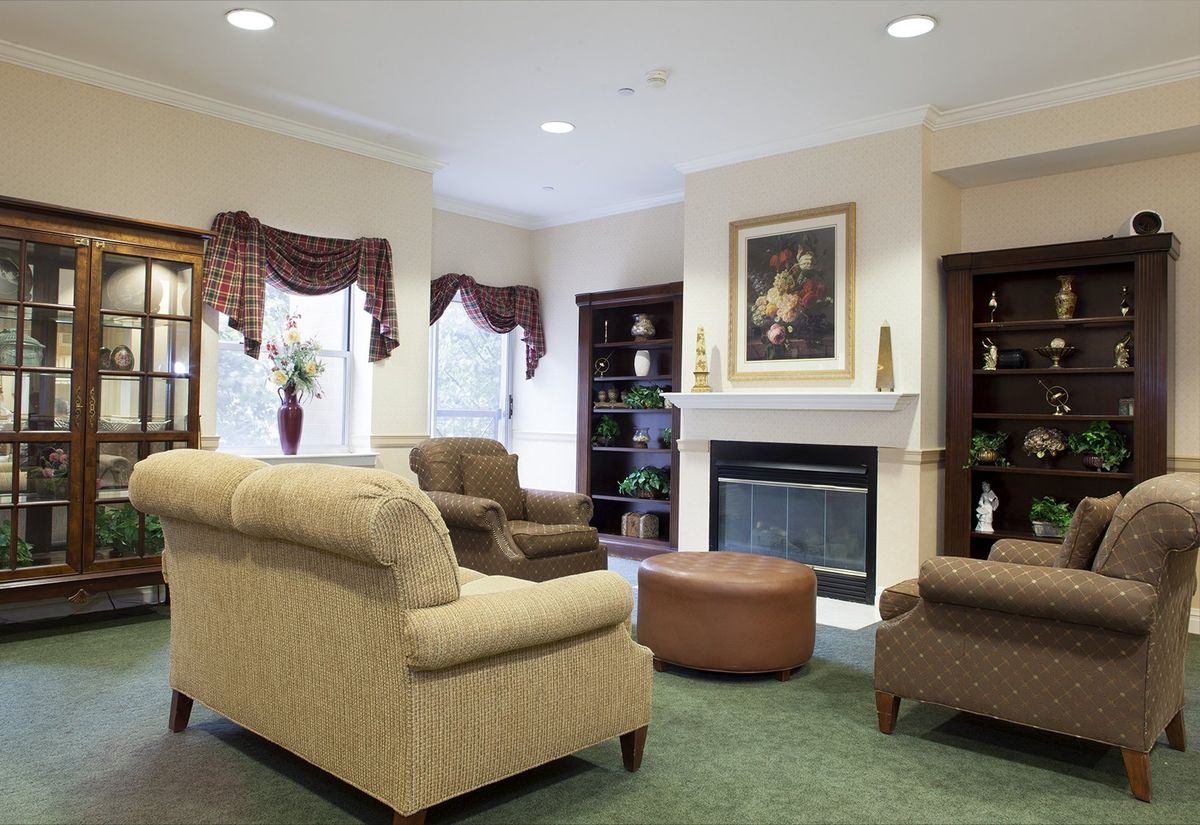 A cozy living room featuring comfortable furniture, a fireplace, and bookshelves.