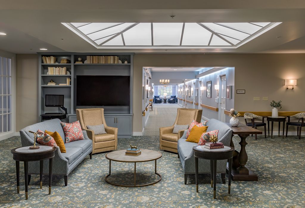 A cozy living room with comfortable seating and a skylight.