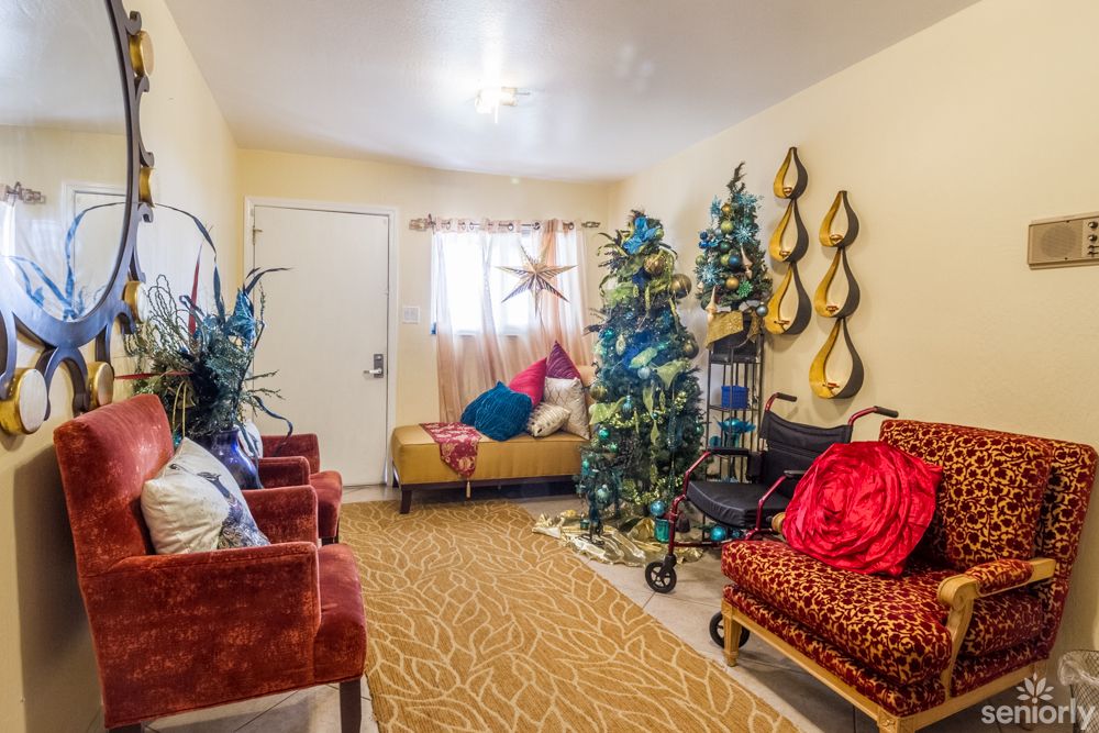 A cozy living room decorated with festive holiday elements, featuring a Christmas tree, colorful ornaments, and comfortable seating.