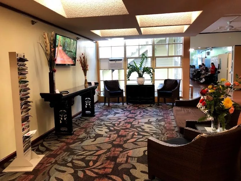 A well-decorated waiting room with comfortable seating and a television.