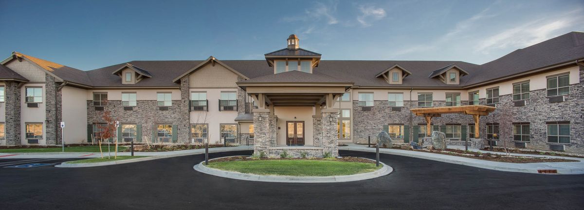 A modern hotel building with a stone facade and welcoming entrance.