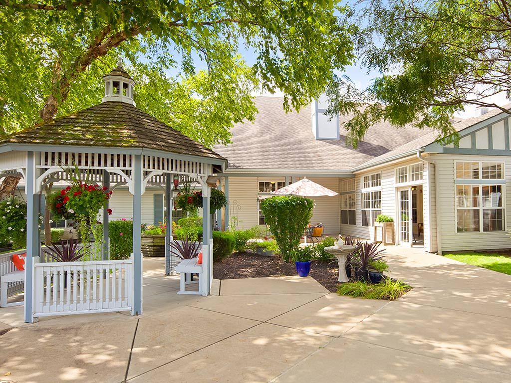 Charming outdoor garden with a gazebo and patio area.