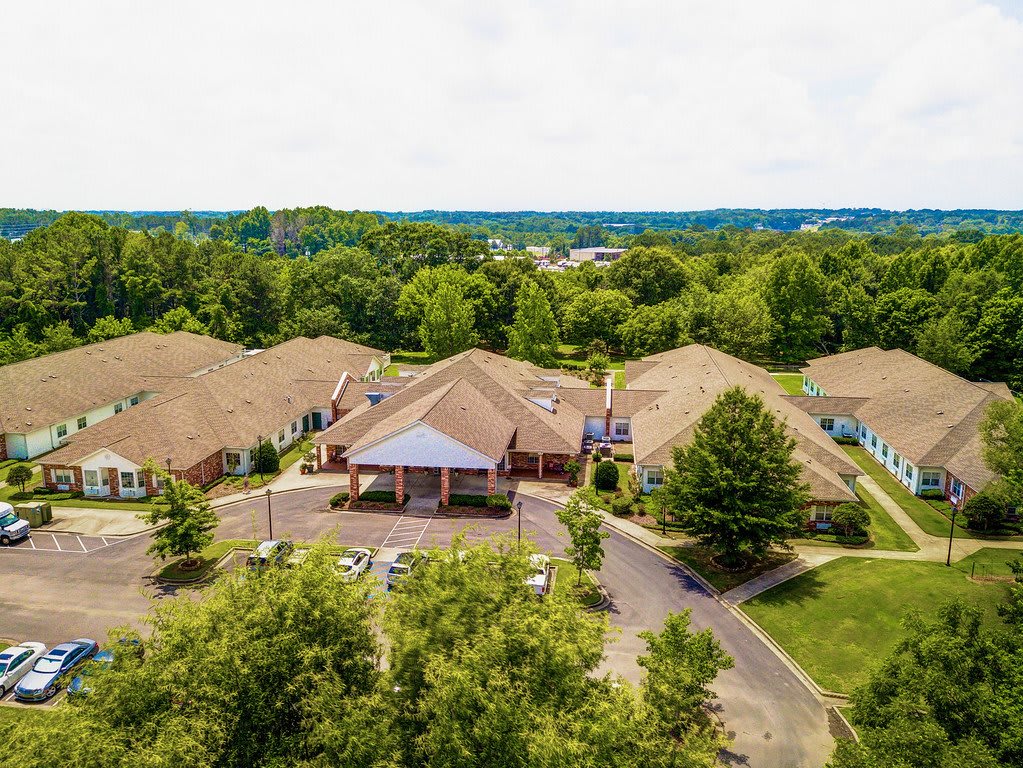 Aerial view of a suburban area with buildings surrounded by trees.