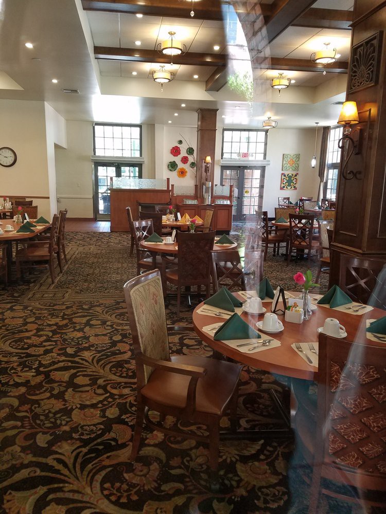 An indoor dining area with set tables and chairs, featuring decorative elements.