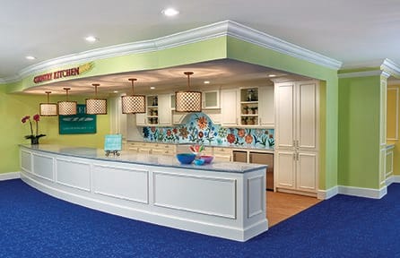 A modern kitchen with a colorful backsplash and elegant lighting.