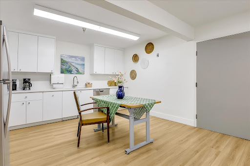 A bright and modern kitchen dining area featuring a simplistic table setup and elegant decor.