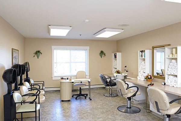 A bright beauty salon interior with chairs and mirrors arranged neatly.