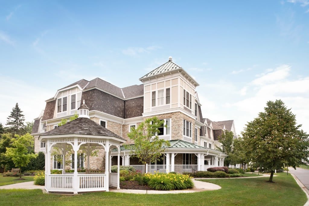 A Victorian-style building with a gazebo in a landscaped garden.