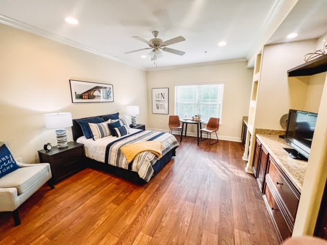 A modern, spacious bedroom with wood flooring and tasteful decor.
