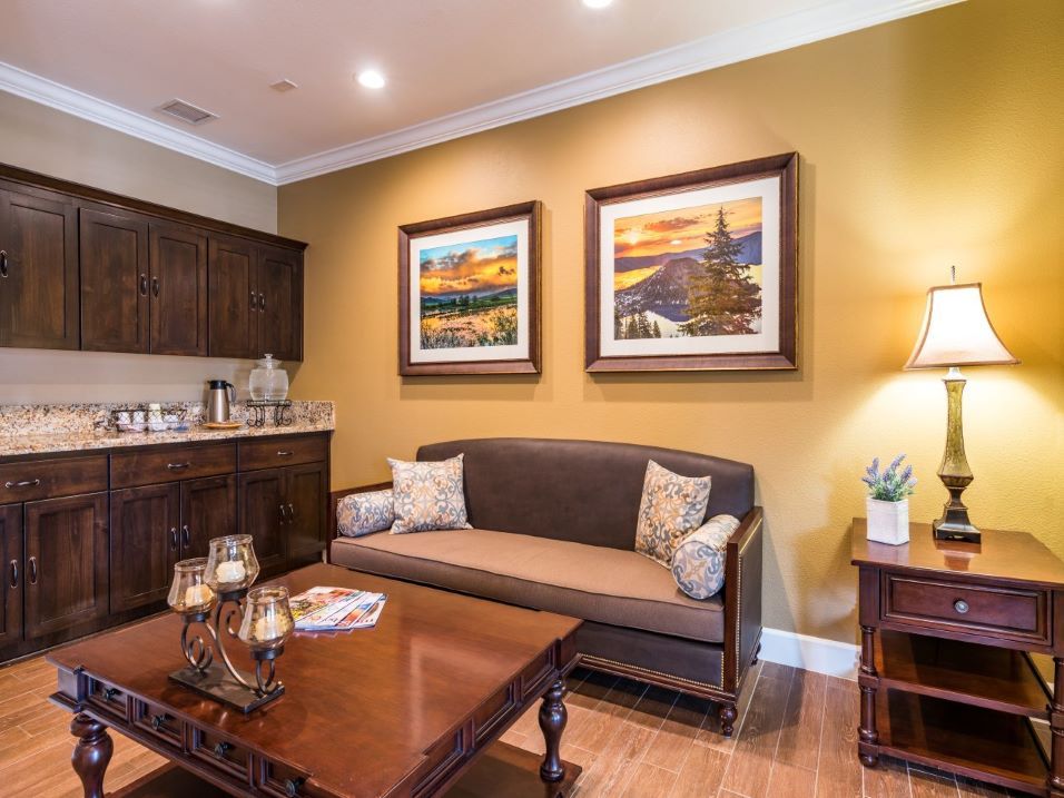 A cozy living room with a sofa and coffee table, adorned with artwork on the walls.