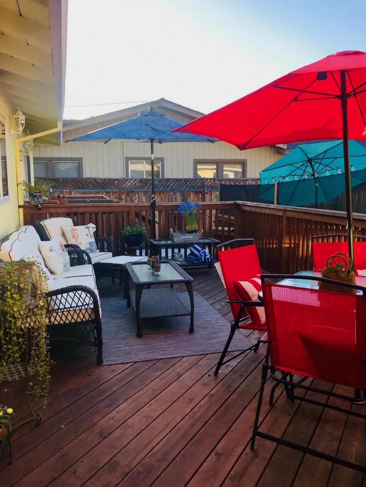 A cozy outdoor patio with colorful umbrellas and comfortable seating.