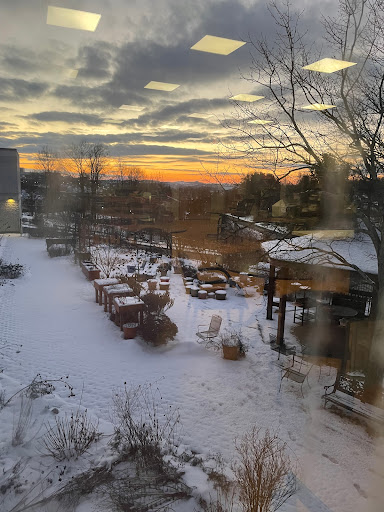 A serene winter sunset illuminates a snowy landscape, creating a tranquil atmosphere.