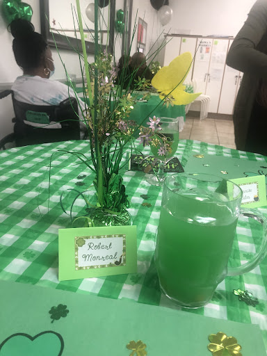 A vibrant green-themed table set for a celebration, featuring a refreshing drink and festive decor.