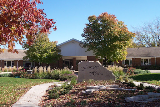 A welcoming view of a building surrounded by vibrant autumn foliage and a well-maintained garden pathway.