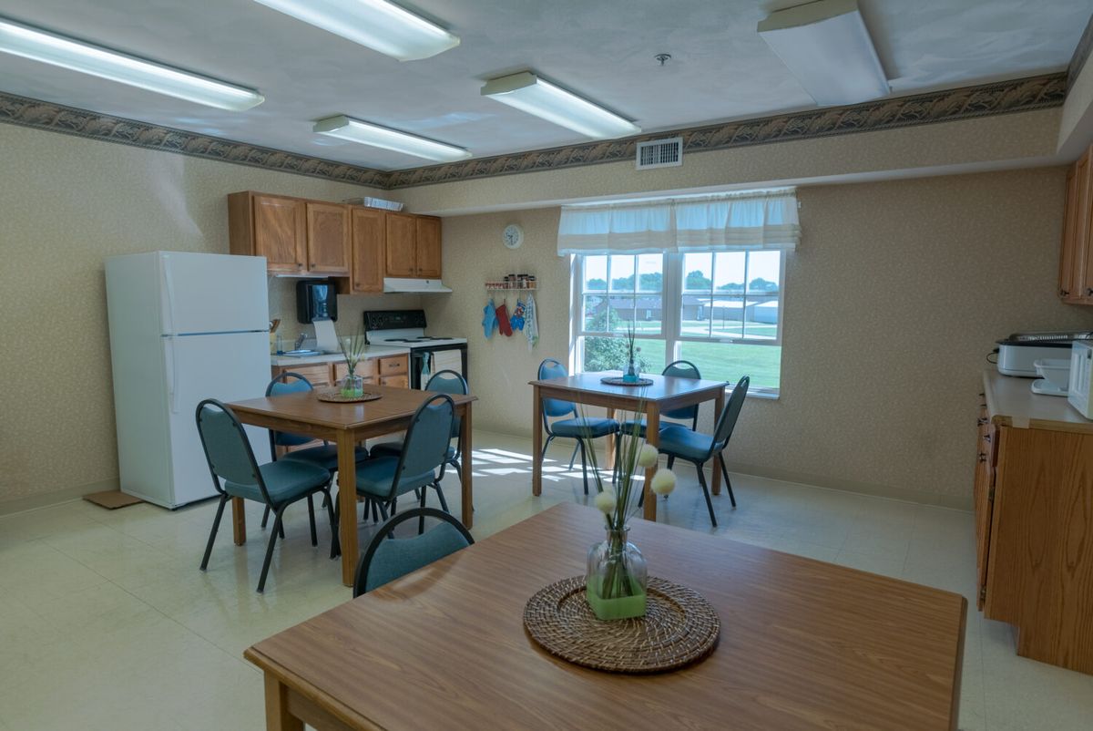 A well-lit kitchen and dining area with wooden furniture and modern appliances.