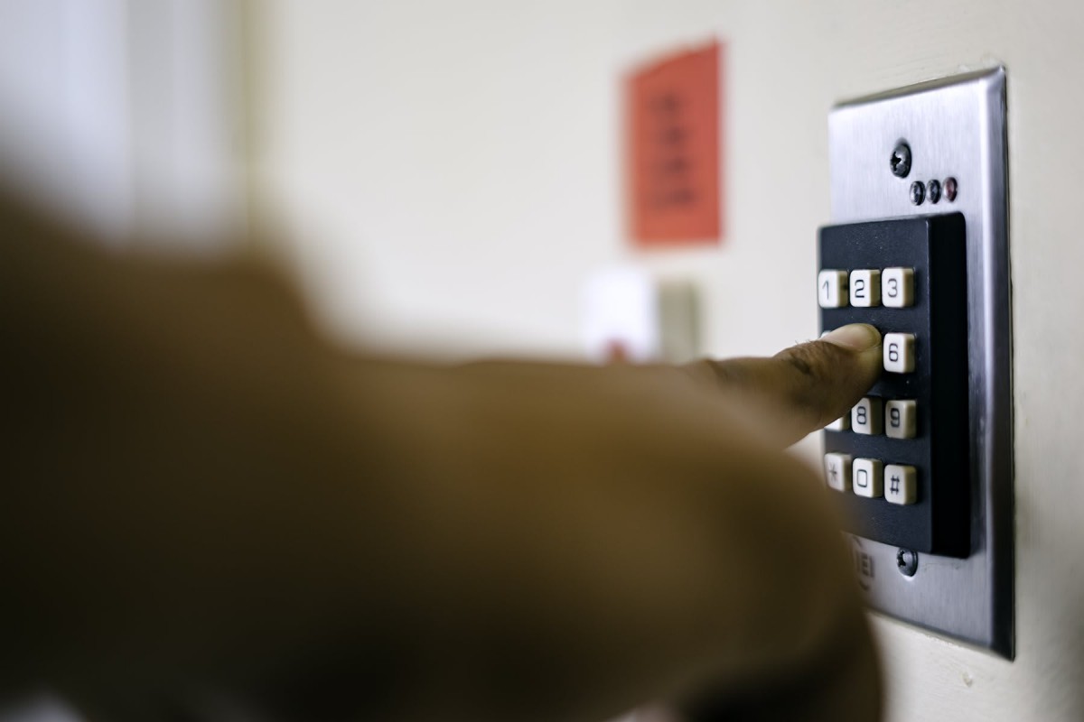 A person enters a code on a security keypad.