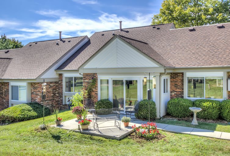 A charming residential house with a landscaped yard and patio.