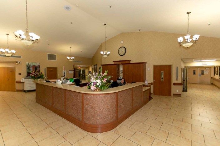 A spacious reception area with a counter and flower arrangement.