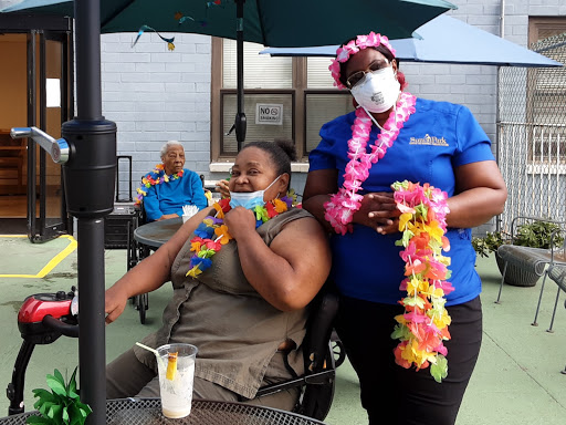 Residents enjoy a tropical-themed outdoor gathering, complete with leis and refreshments.