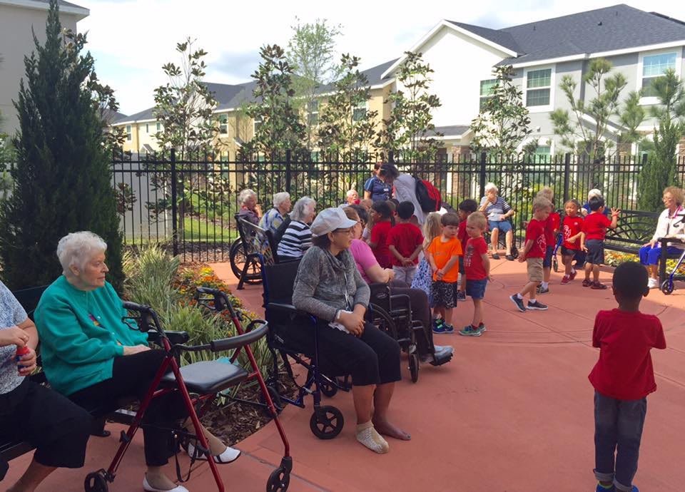 A community event bringing together elderly individuals and children in an outdoor setting.