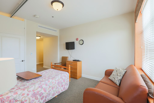 A cozy interior showcasing a well-furnished room with a bed, sofa, and television.